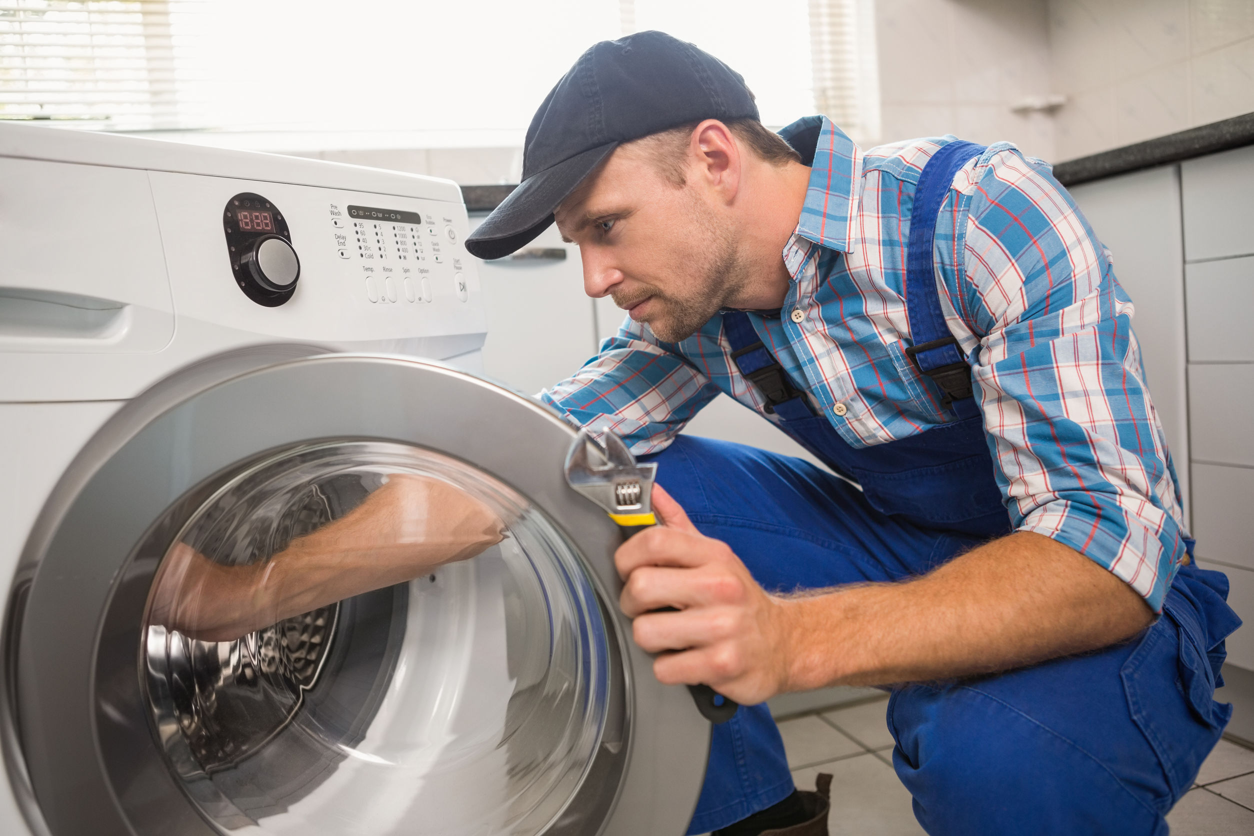 33949793 - handyman fixing a washing machine in the kitchen